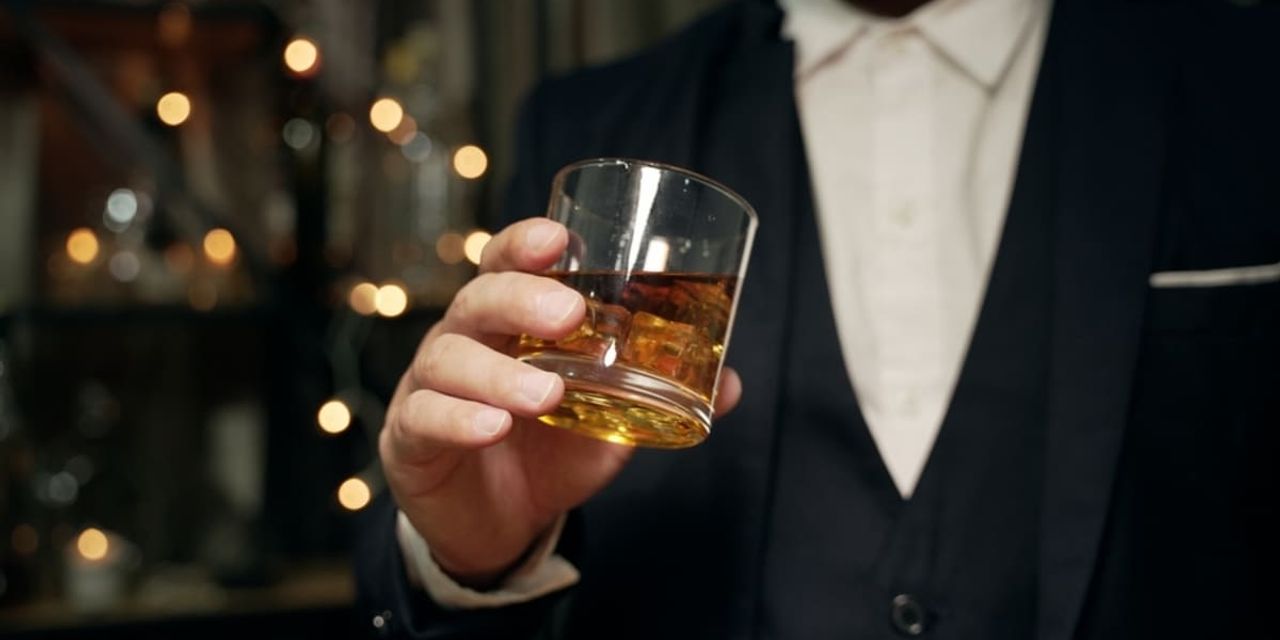 barbat tinand in mana un pahar de whiskey barbat tinand in mana un pahar de whiskey