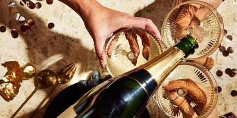 femeie turnand sampanie in pahare de Revelion femeie turnand sampanie in pahare de Revelion
